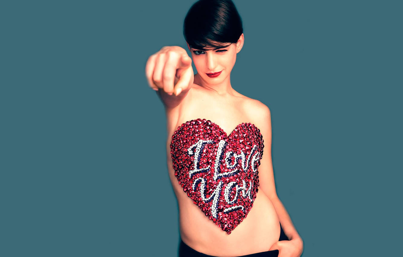 短黑髮女性指向觀眾，胸前覆蓋著帶有「I Love You」文字的紅色閃光心形。