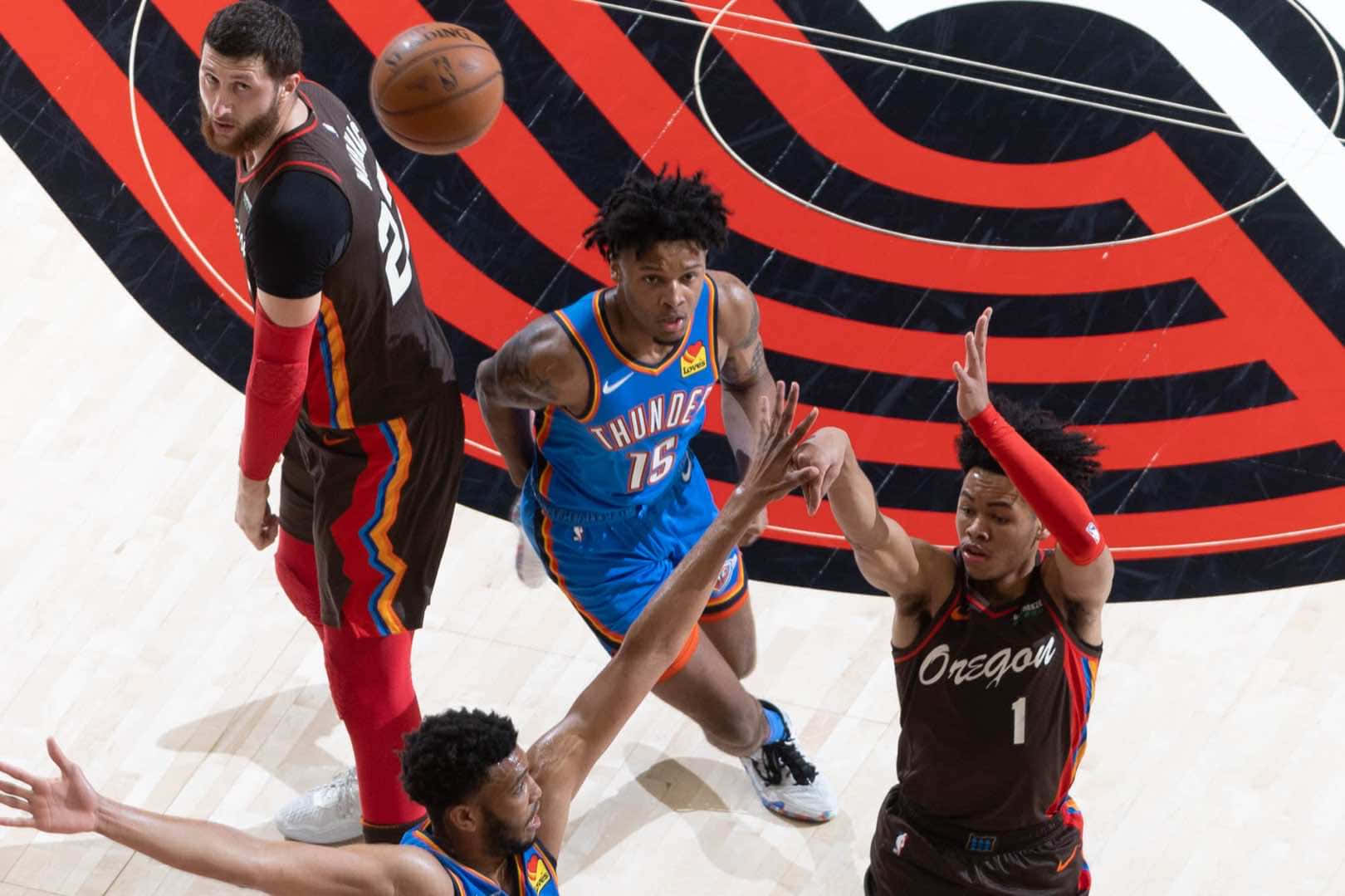 四位籃球運動員在比賽中爭奪一個鬆散的球。