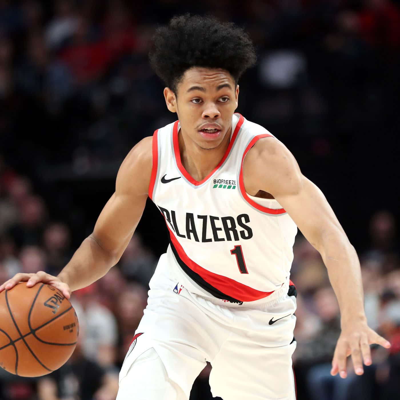 籃球運動員在比賽中運球，身穿白色Blazers球衣。