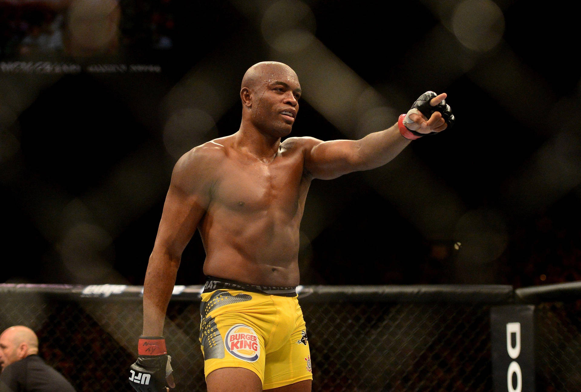 MMA拳手穿著黃色短褲在八角籠內慶祝勝利。
