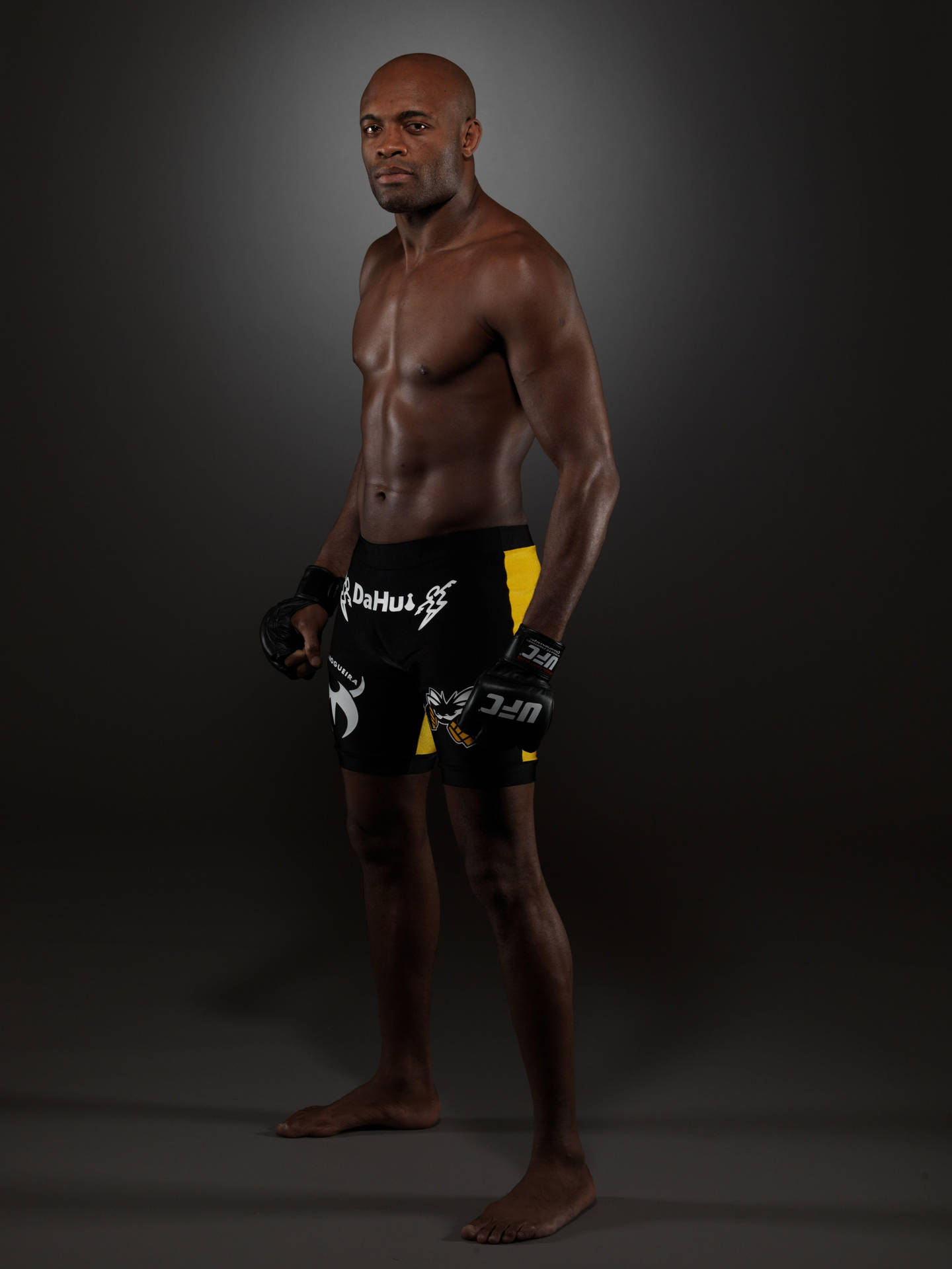 專業綜合格鬥選手穿著UFC裝備在黑暗背景前擺姿勢。