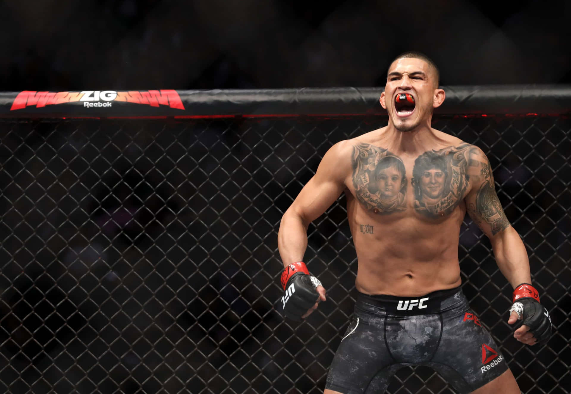MMA拳手在UFC八角籠內展示紋身慶祝勝利。