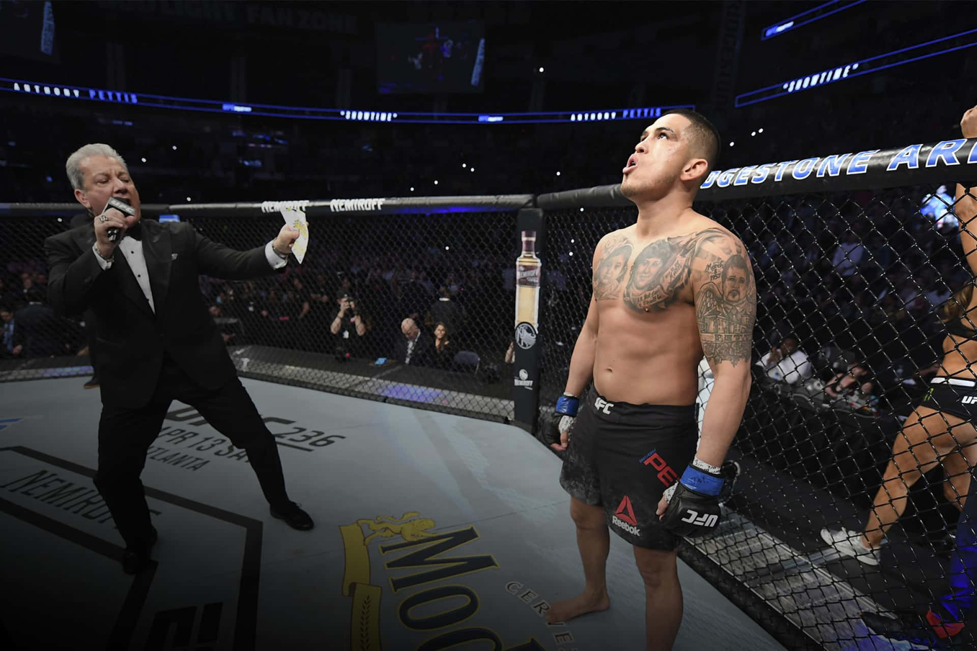 MMA拳手在八角籠中慶祝勝利，裁判宣布勝利。