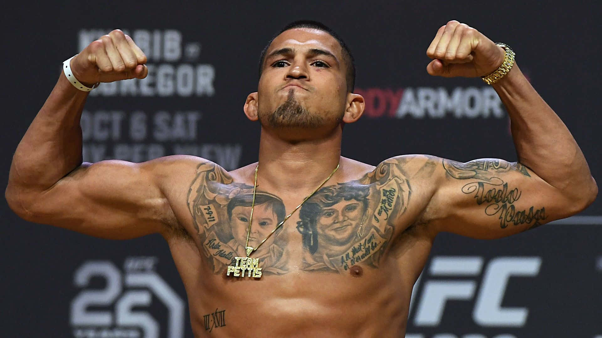 一位赤裸上身的MMA拳手在UFC稱重活動中彎曲手臂。