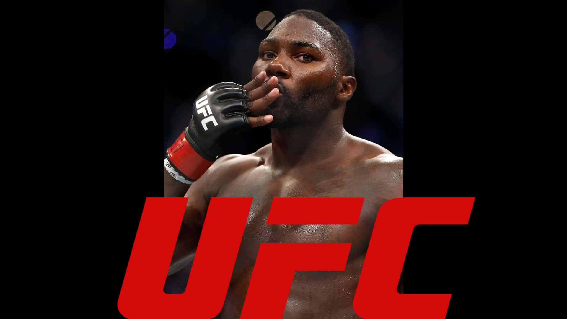 安東尼·約翰遜於2016年T-Mobile Arena UFC 202賽事慶祝勝利 壁紙 — 一位肌肉發達的UFC拳手戴著黑色手套，在深色背景下以專注的表情遮住嘴巴。