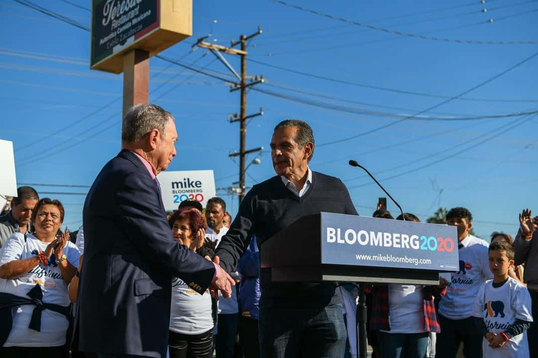 Mike Bloomberg 在競選活動中與支持者握手。