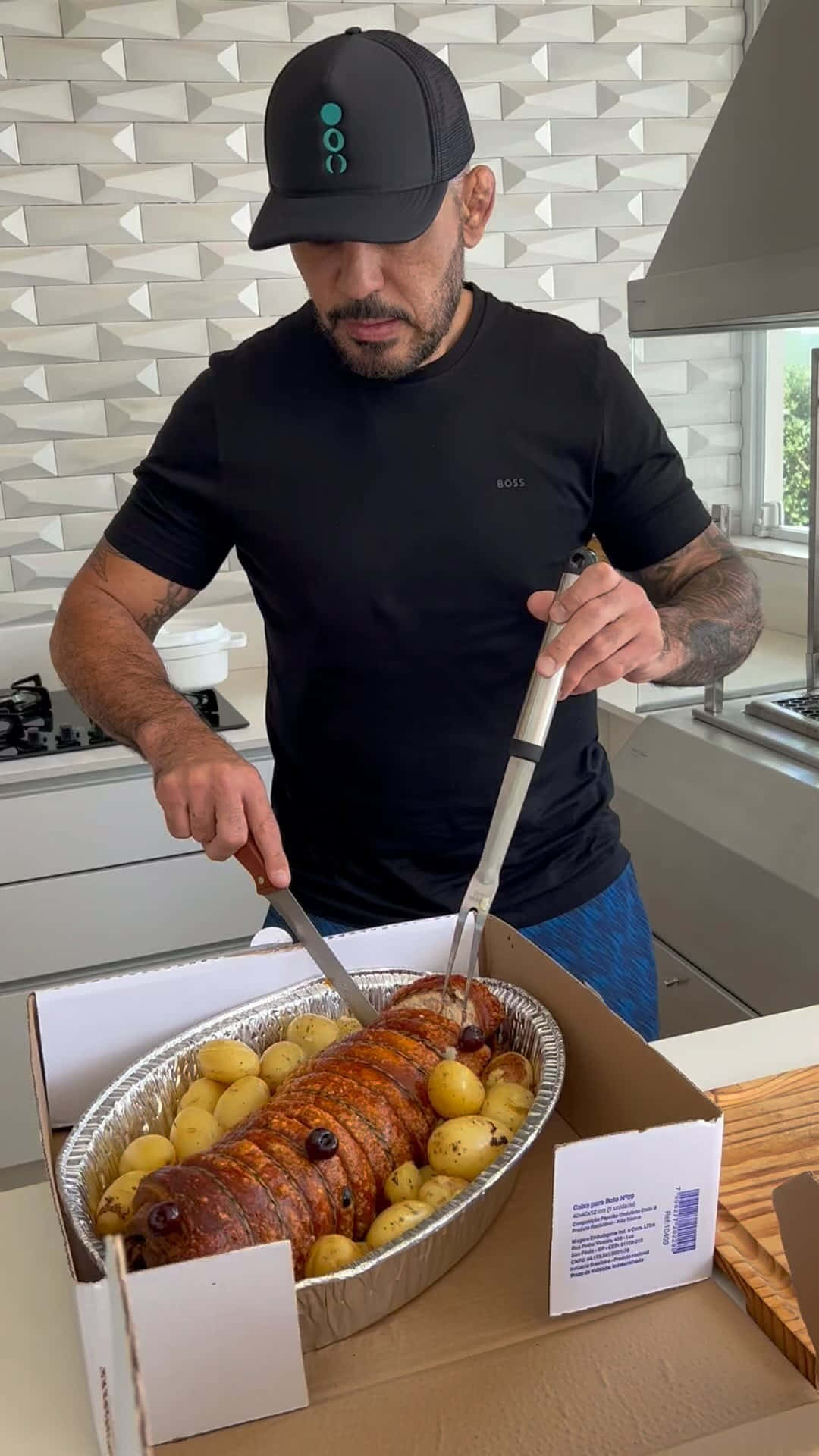 男子在現代廚房裡切烤豬腰肉配馬鈴薯。