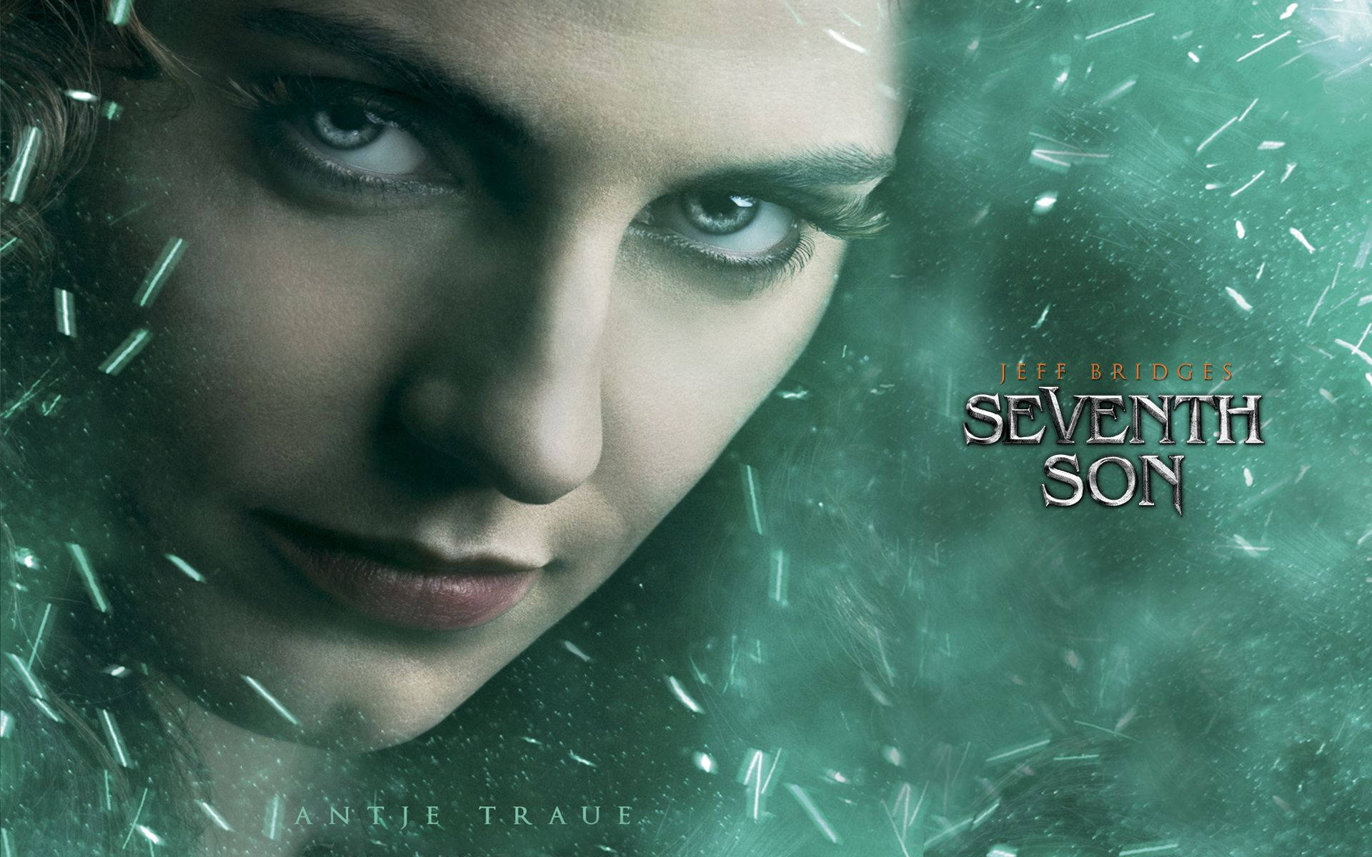 安潔特·特羅伊出演《第七子》 壁紙 — Antje Traue 嘅特寫肖像，帶有強烈嘅眼神，被發光嘅綠色魔法粒子包圍，喺一個神秘嘅電影場景中。