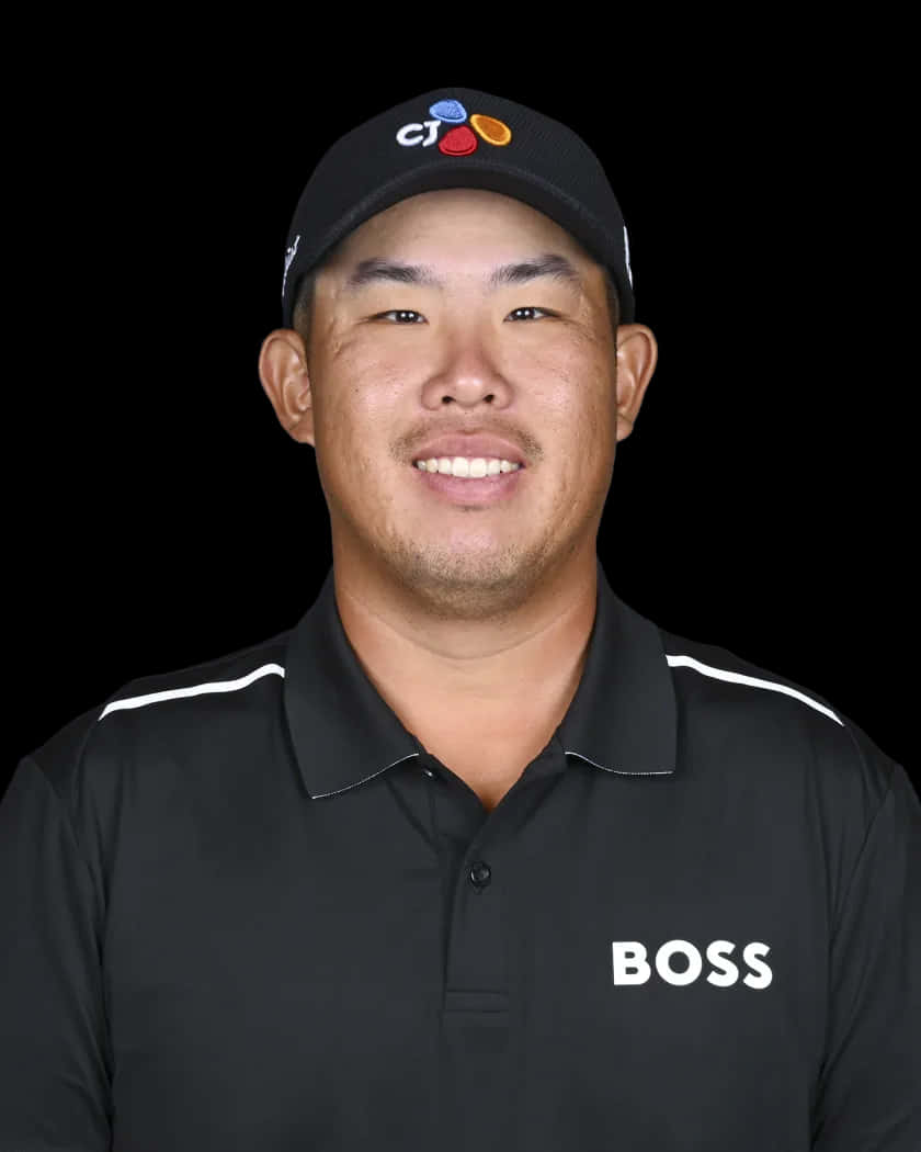 專業高爾夫球手戴著黑色帽子和BOSS Polo衫微笑。
