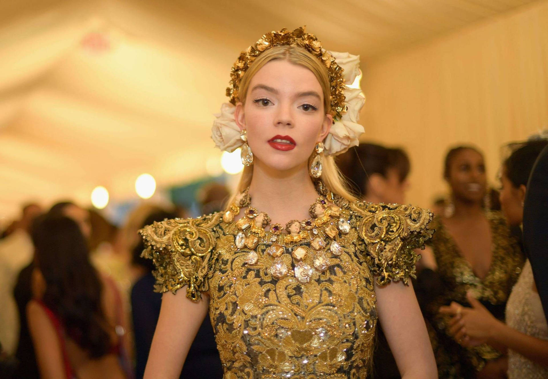 穿著精緻金色禮服和花卉頭飾的女性在正式聚會中。