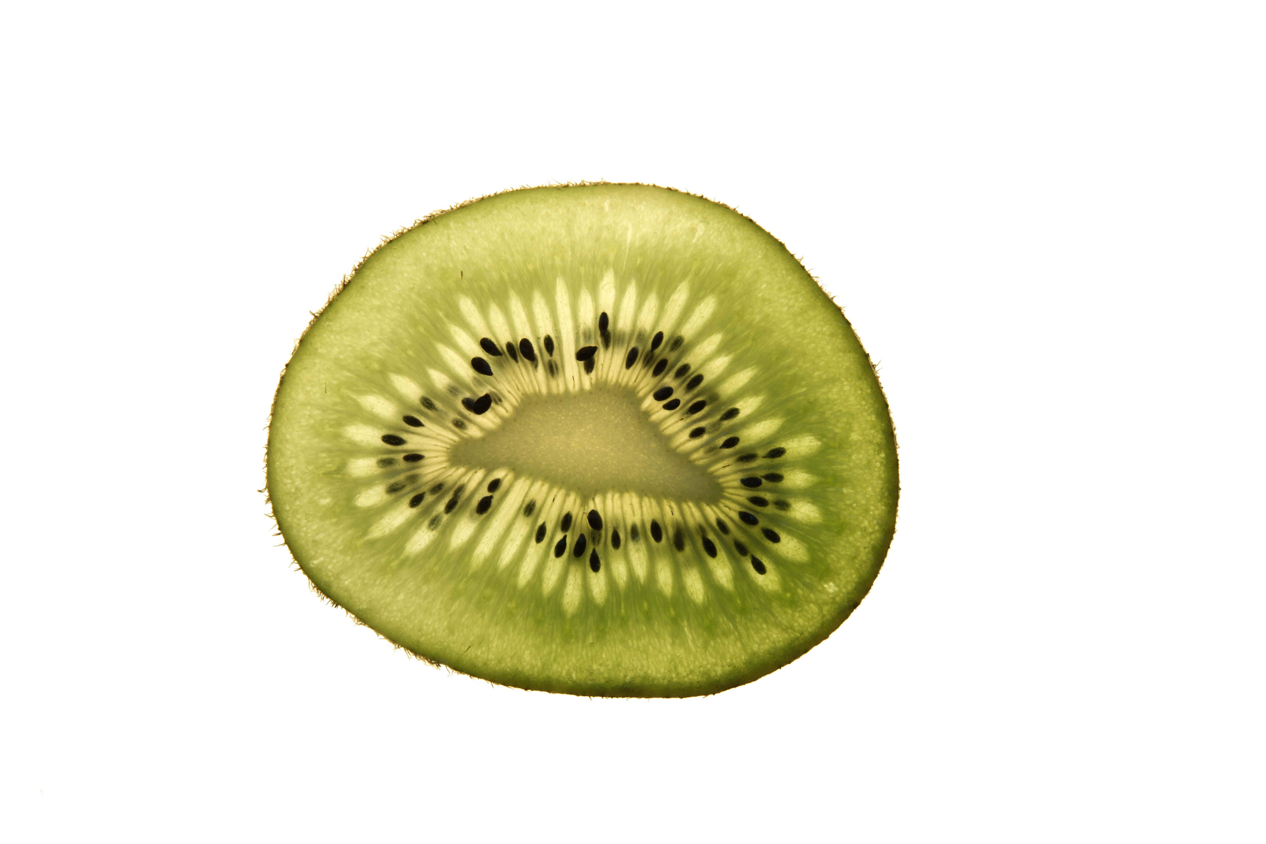 Kiwi 桌布 壁紙 — 完美切片的奇異果在純白背景下展現出充滿活力的綠色果肉和黑色種子。