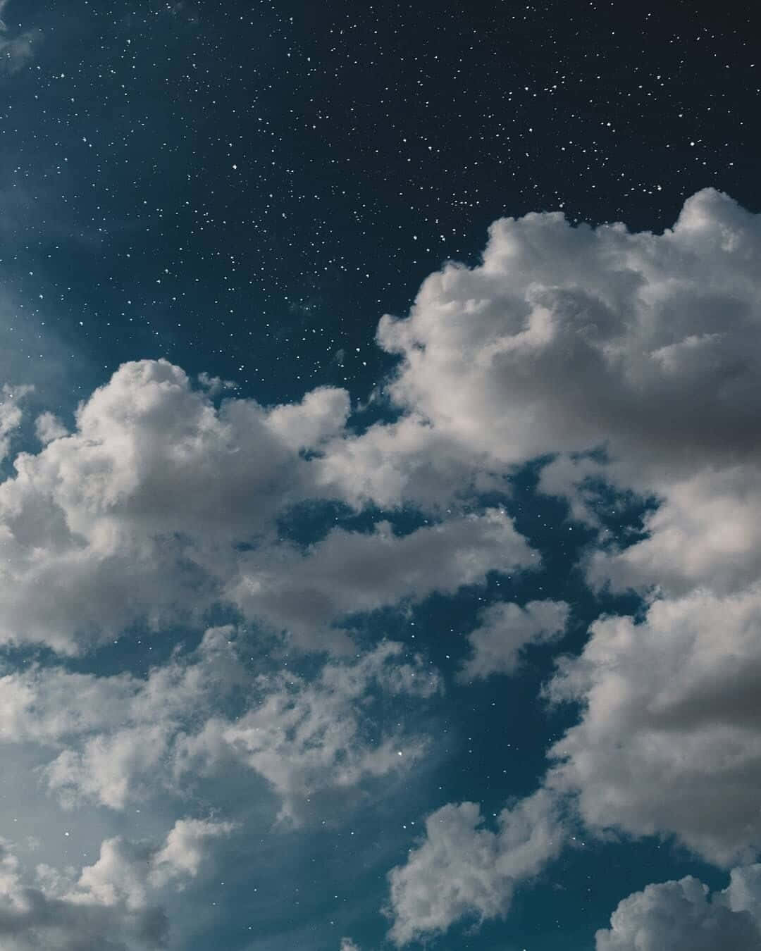 星空下，柔軟的雲朵在靛藍色的天空中飄蕩。