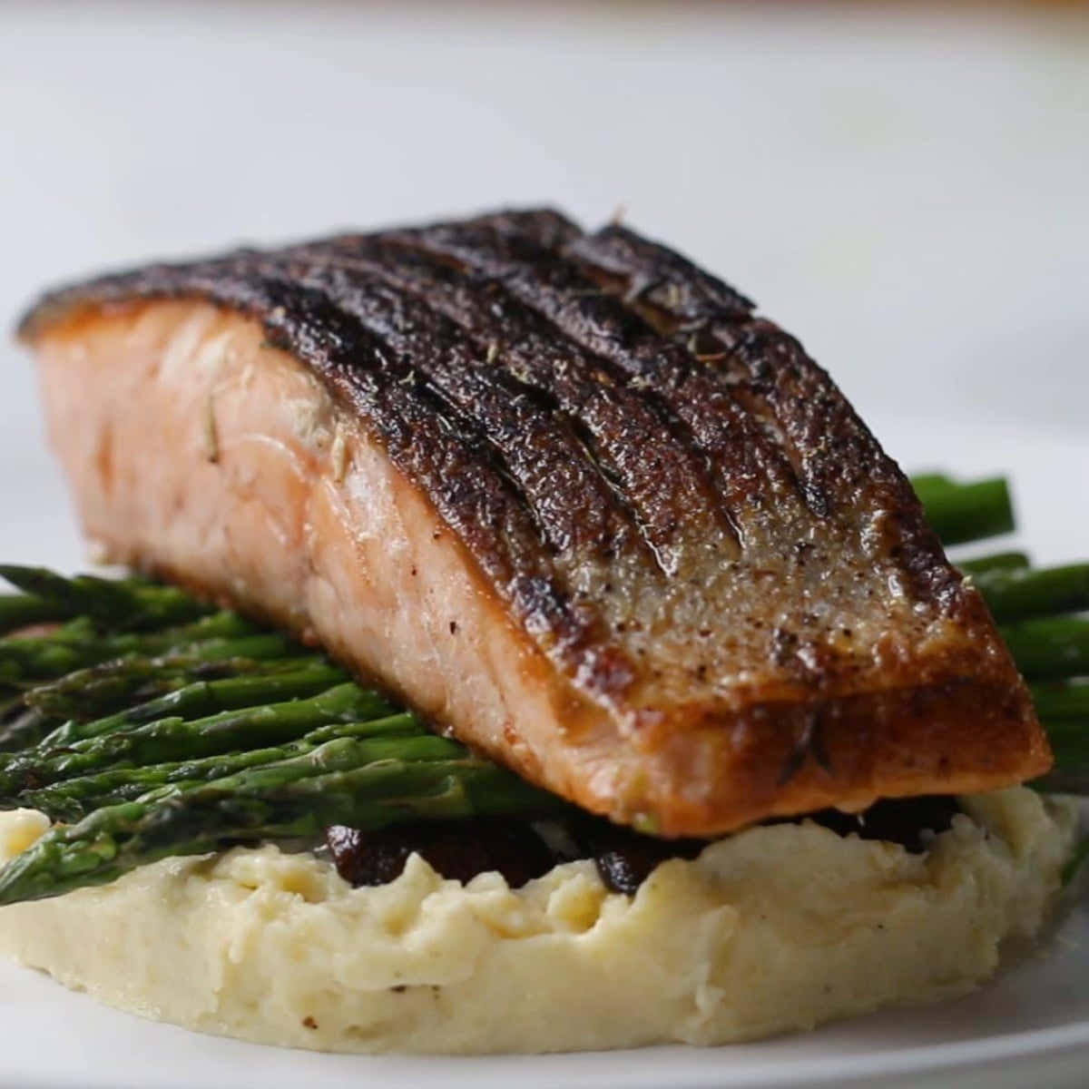 Salmon 桌布 壁紙 — 完美烤製的三文魚柳（帶焦脆魚皮）置於烤蘆筍和忌廉薯蓉之上。