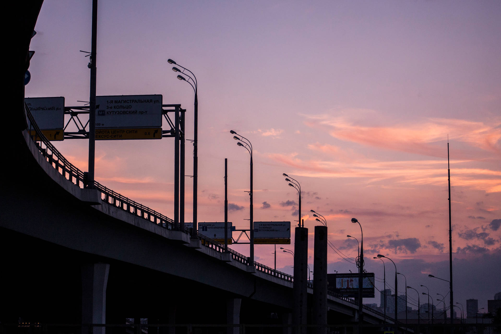 高速公路高架橋在色彩繽紛的黃昏天空下形成剪影。