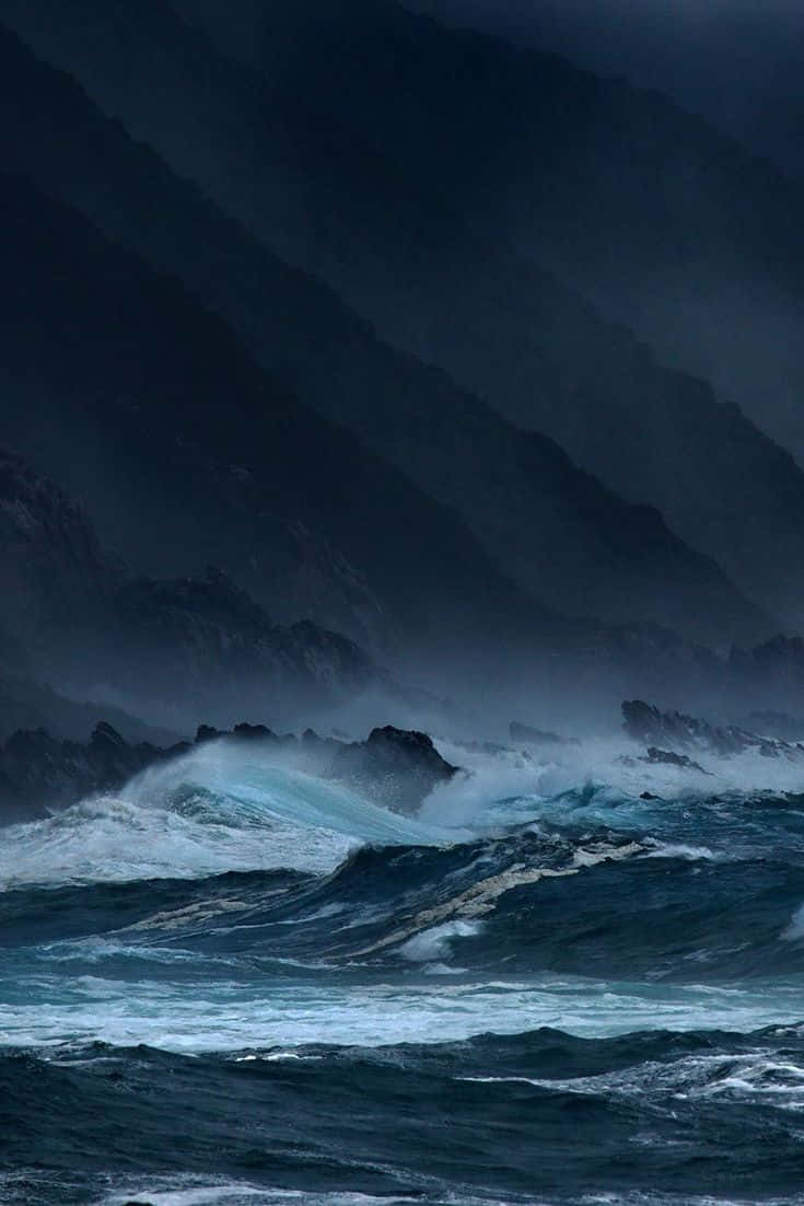 暴風雨的海浪在陰暗的天空下衝擊著岩石懸崖。