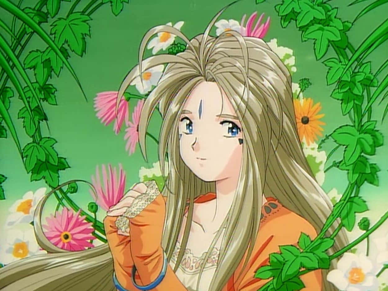 完美配對——《我的女神》 壁紙 — 長金髮藍眼動漫女孩，手持花朵，被茂密綠色藤蔓和繽紛花朵環繞，溫柔微笑。