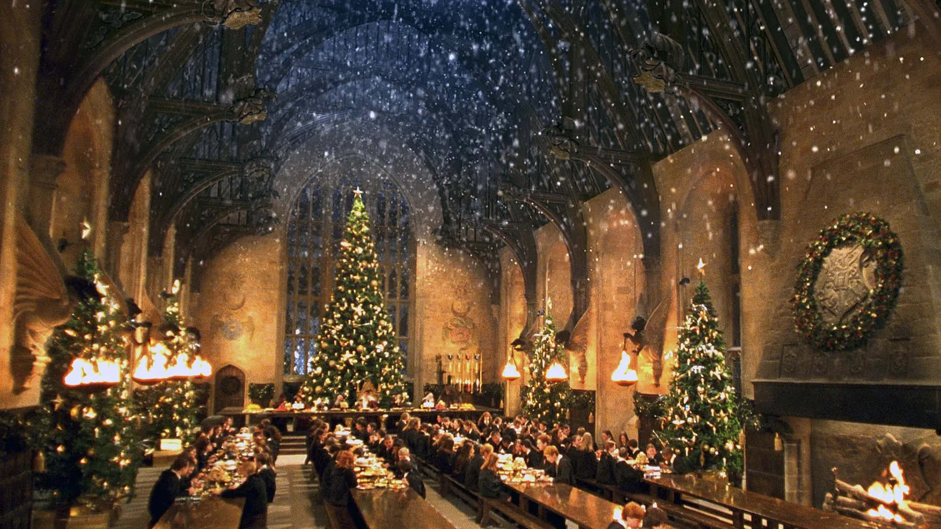 Harry Potter Christmas 桌布 壁紙 — 宏偉城堡的宴會廳，學生們在飄雪魔法天花下、聳立聖誕樹旁用餐。