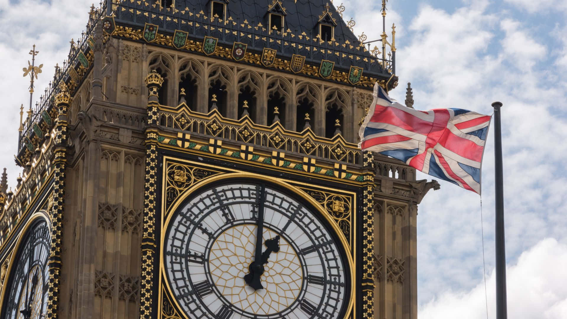 UK 桌布 壁紙 — 宏偉的伊利沙伯塔，帶有華麗的鐘面，在部分多雲的天空下飄揚的英國國旗。