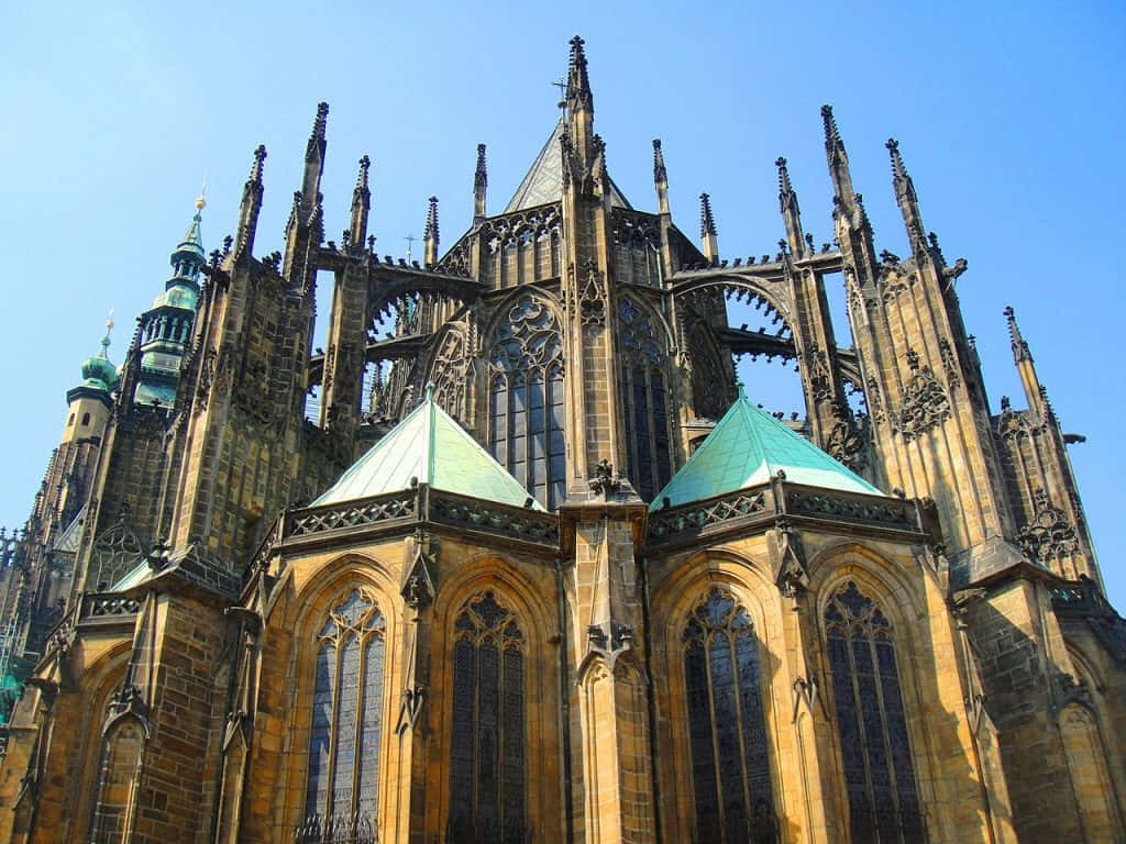 Gothic Architecture 桌布 壁紙 — 宏偉的哥德式大教堂，擁有精緻的尖塔和彩色玻璃窗，在清澈的藍天下。