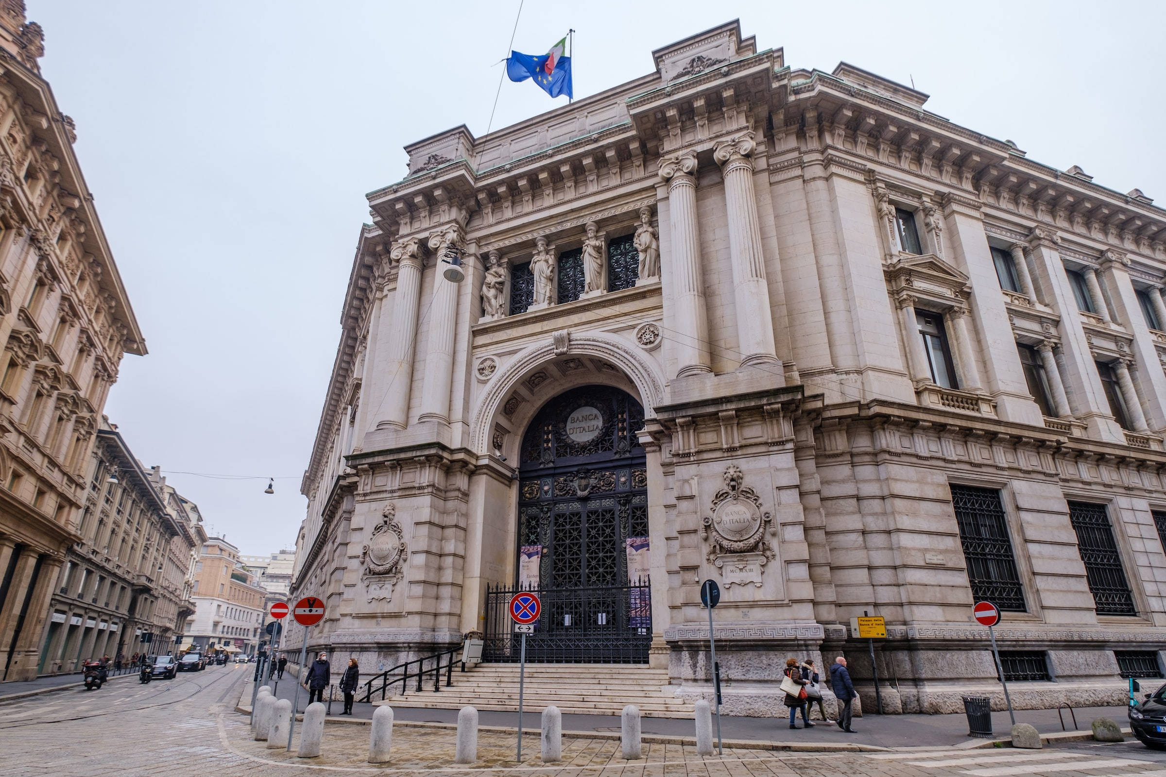 Bank Milano Banca D'Italia 壁紙 — 宏偉的新古典主義銀行建築，在陰天襯托下，飾有華麗的柱子和雕像。