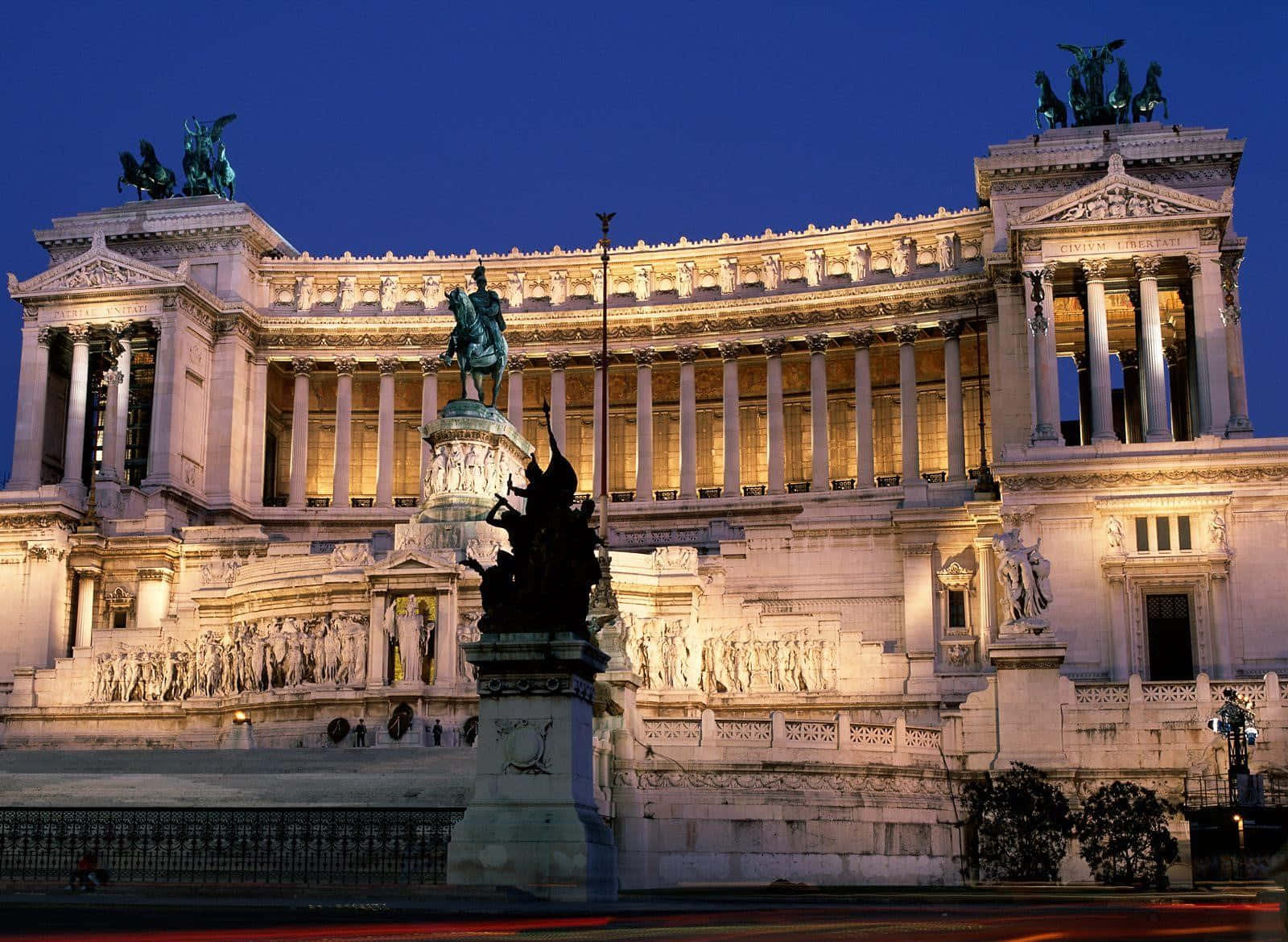 Rome 桌布 壁紙 — 宏偉的照明紀念碑，雕像和柱子在暮色天空中閃耀。
