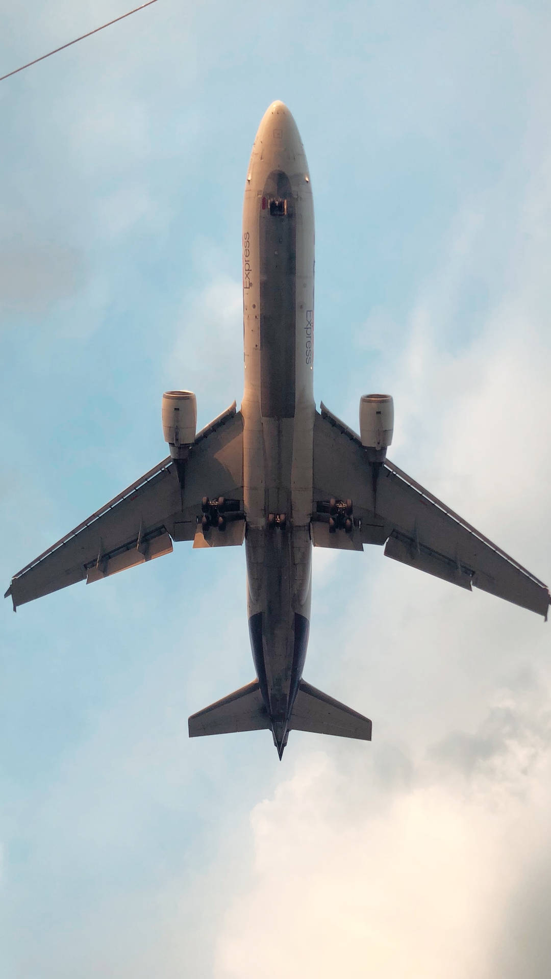 一架大型客機在部分多雲的天空中飛過頭頂。