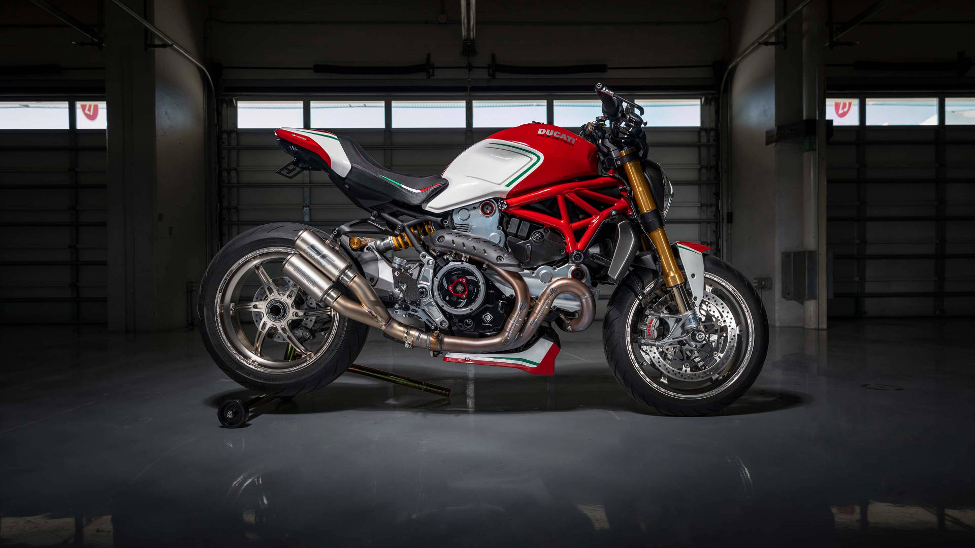 黑暗工業車庫中的紅白黑色Ducati電單車。