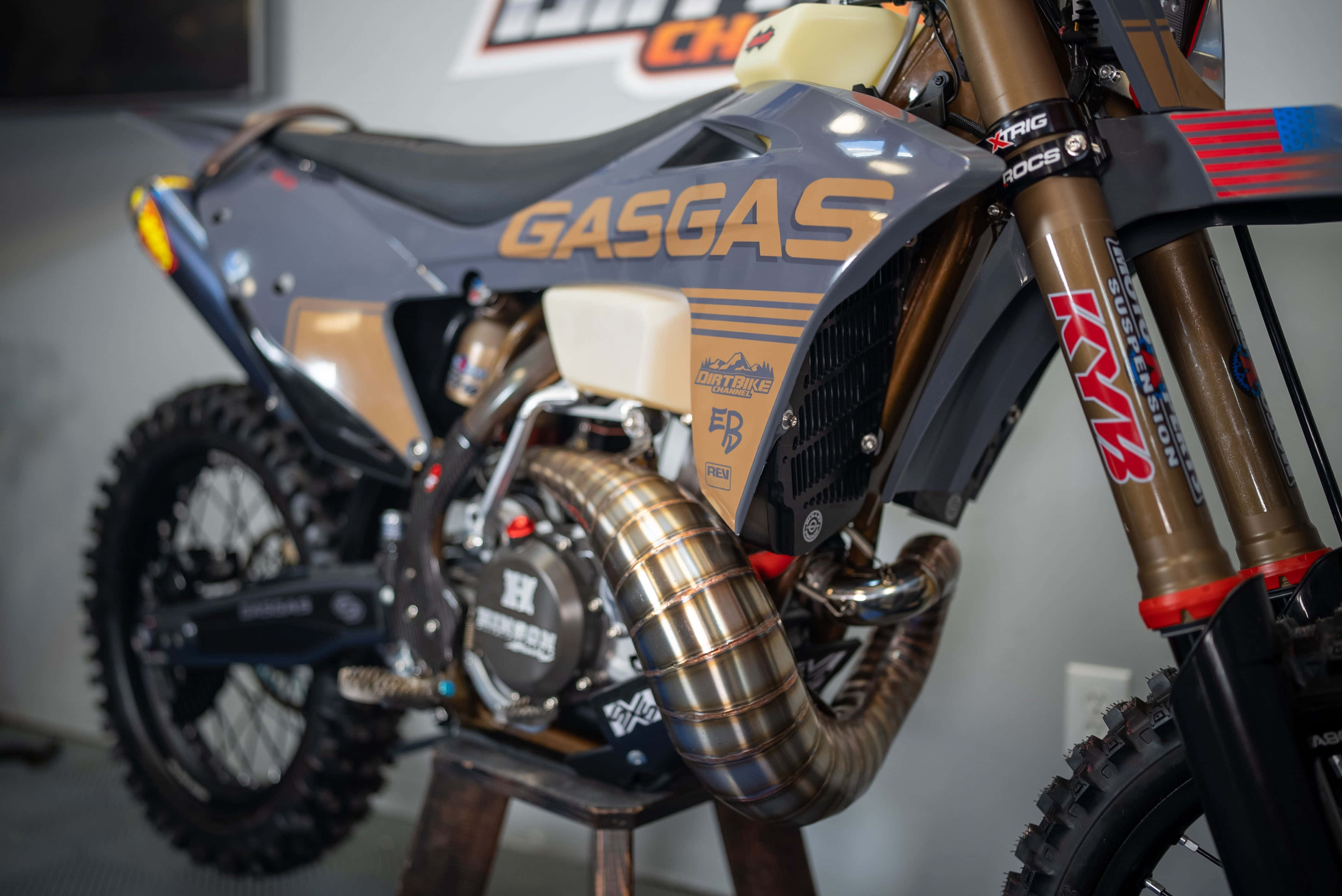 Dirtbike 桌布 壁紙 — 室內展示的時尚灰色和金色GasGas越野電單車特寫，配備KTM懸掛和定制排氣管。