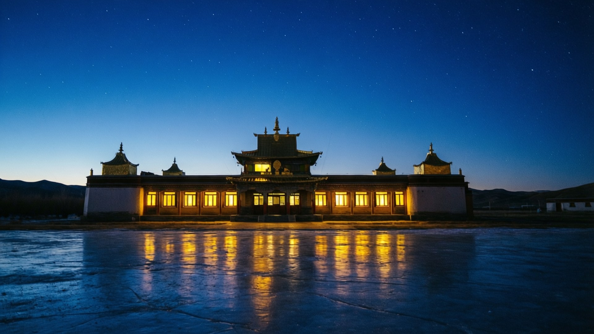 寺廟溫暖燈光倒映在冰凍湖面，繁星夜空下