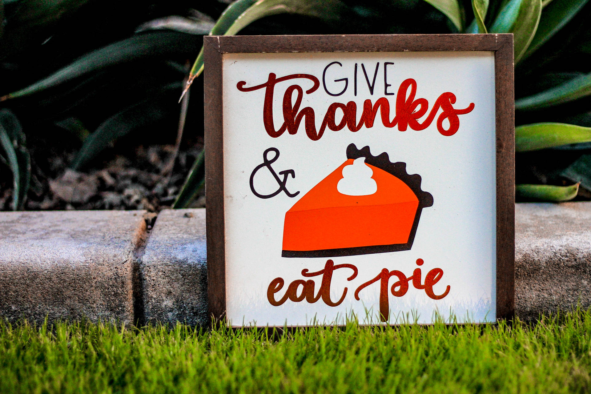 一個帶有餡餅插圖的木牌寫著 give thanks and eat pie。