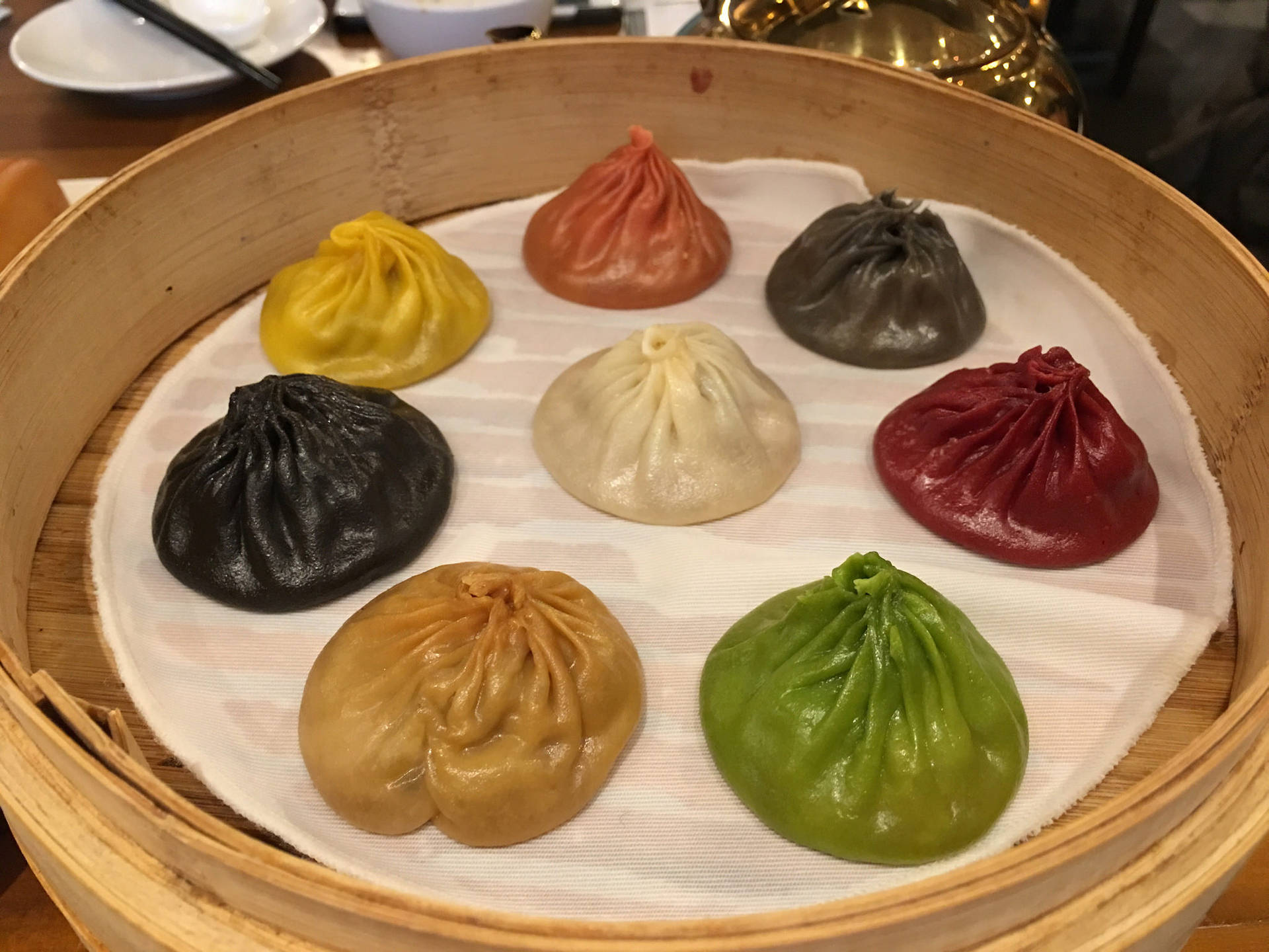 竹蒸籠上七個不同顏色的蒸餃。