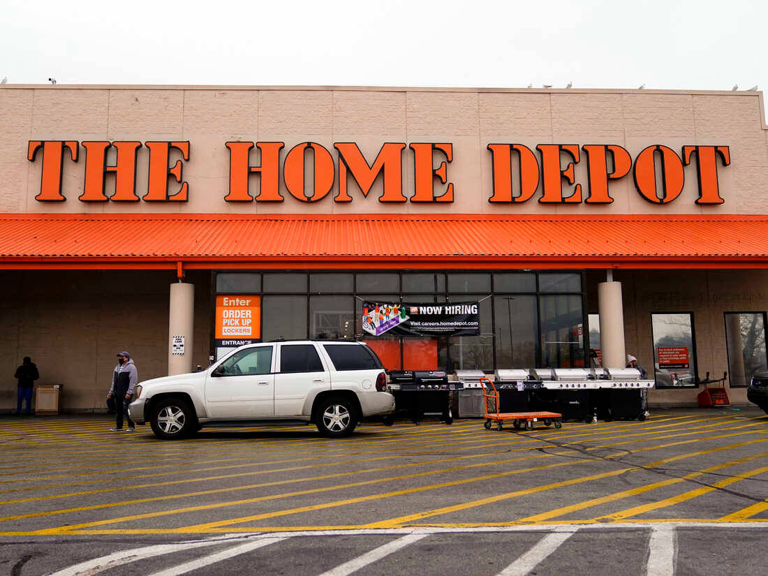白色SUV停在Home Depot商店前，有橙色標誌和黃色停車線。
