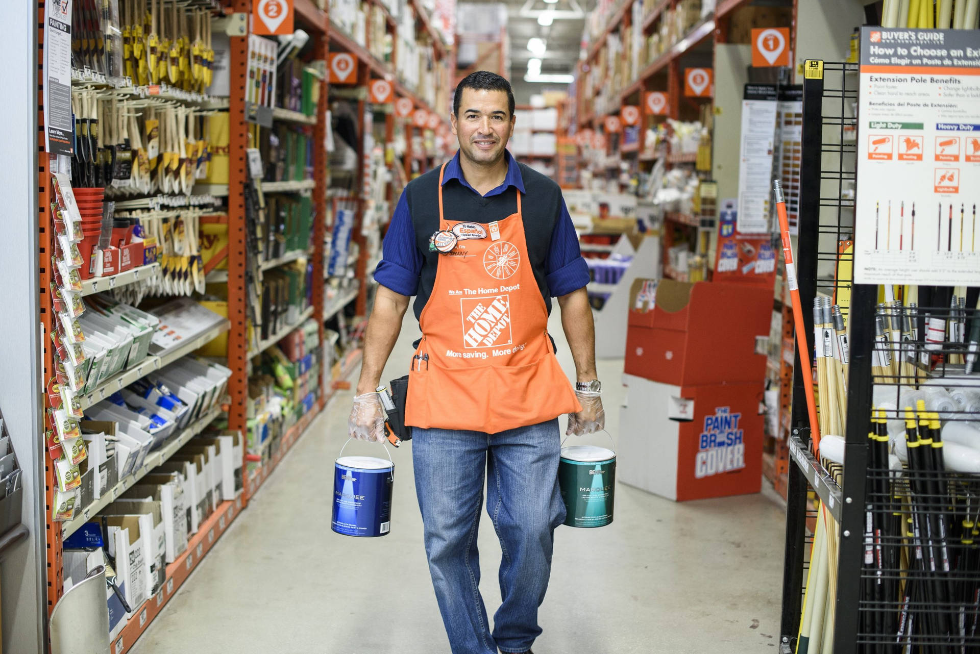 Home Depot員工在五金店走廊搬運油漆罐。