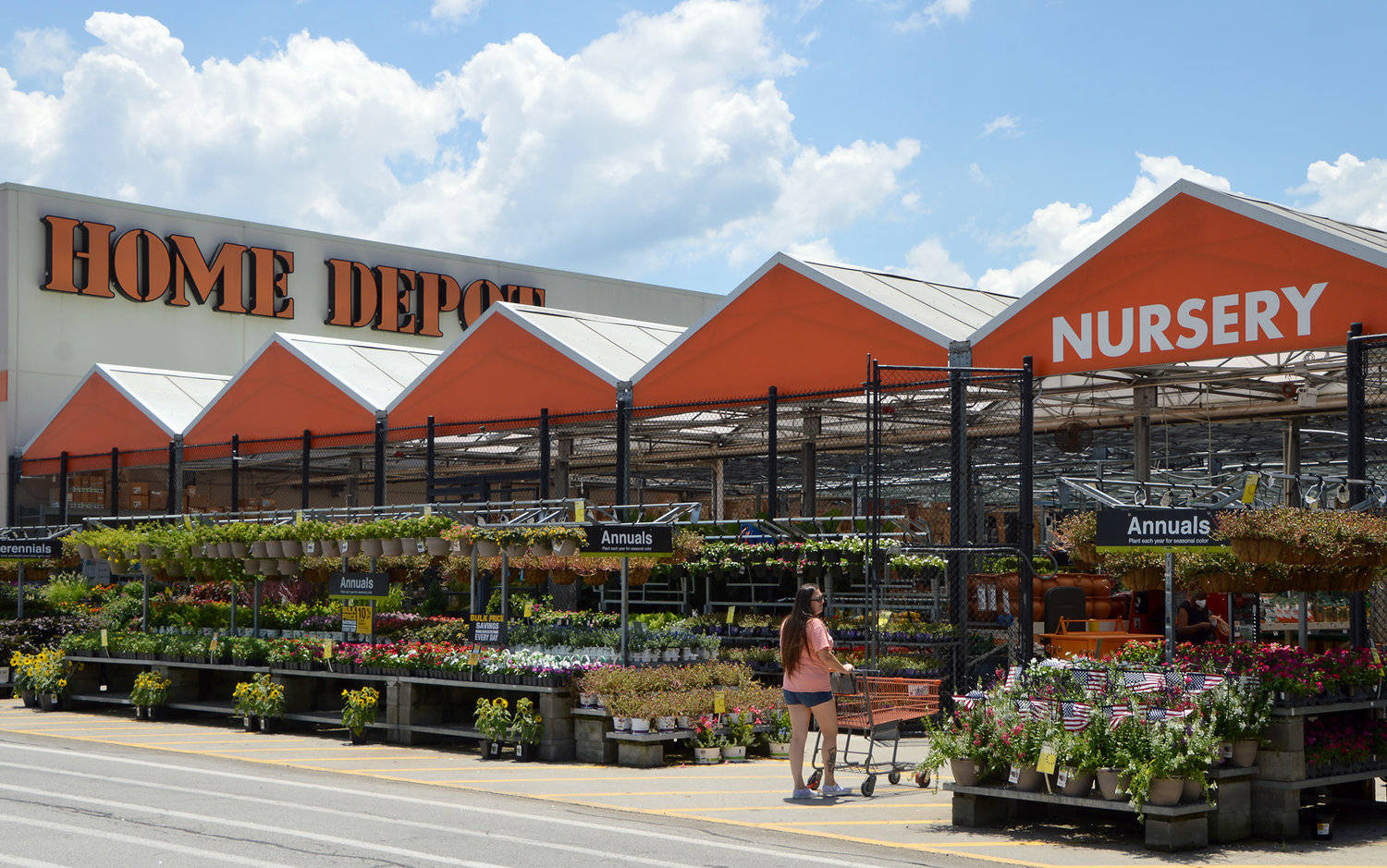 女性在陽光明媚的日子在 Home Depot 苗圃選購花卉