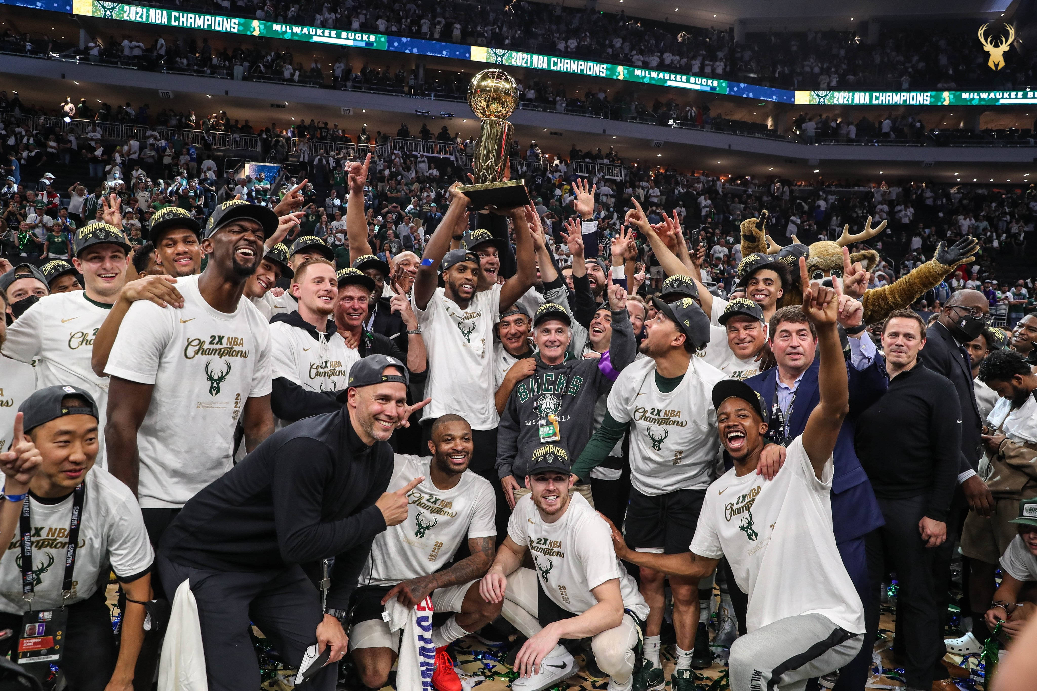 密爾瓦基公鹿隊2021年NBA冠軍慶祝 壁紙 — 密爾沃基公鹿籃球隊慶祝贏得2021年NBA總冠軍，在場館內高舉獎盃，周圍有五彩紙屑和歡呼的球迷。