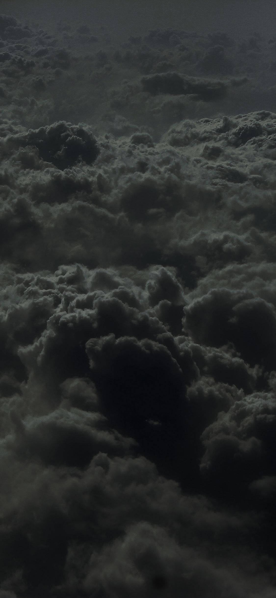 雲朵 桌布 壁紙 — 密集嘅深色雲層喺陰沉嘅大氣天空中旋轉嘅航拍視圖。