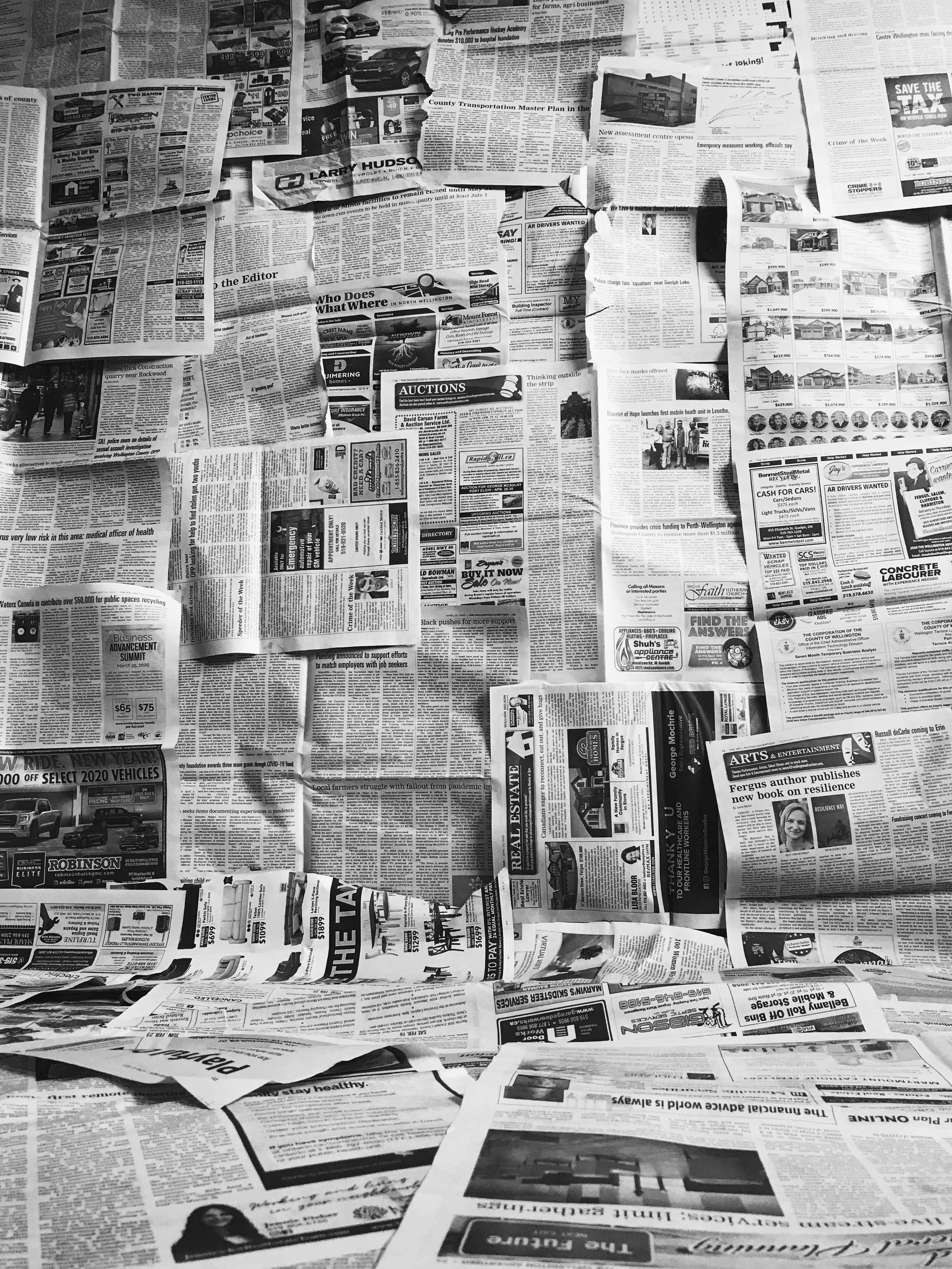 Black And White Newspaper 桌布 壁紙 — 密集的黑白拼貼畫，由重疊的報紙剪報組成，覆蓋表面，包含標題和廣告。