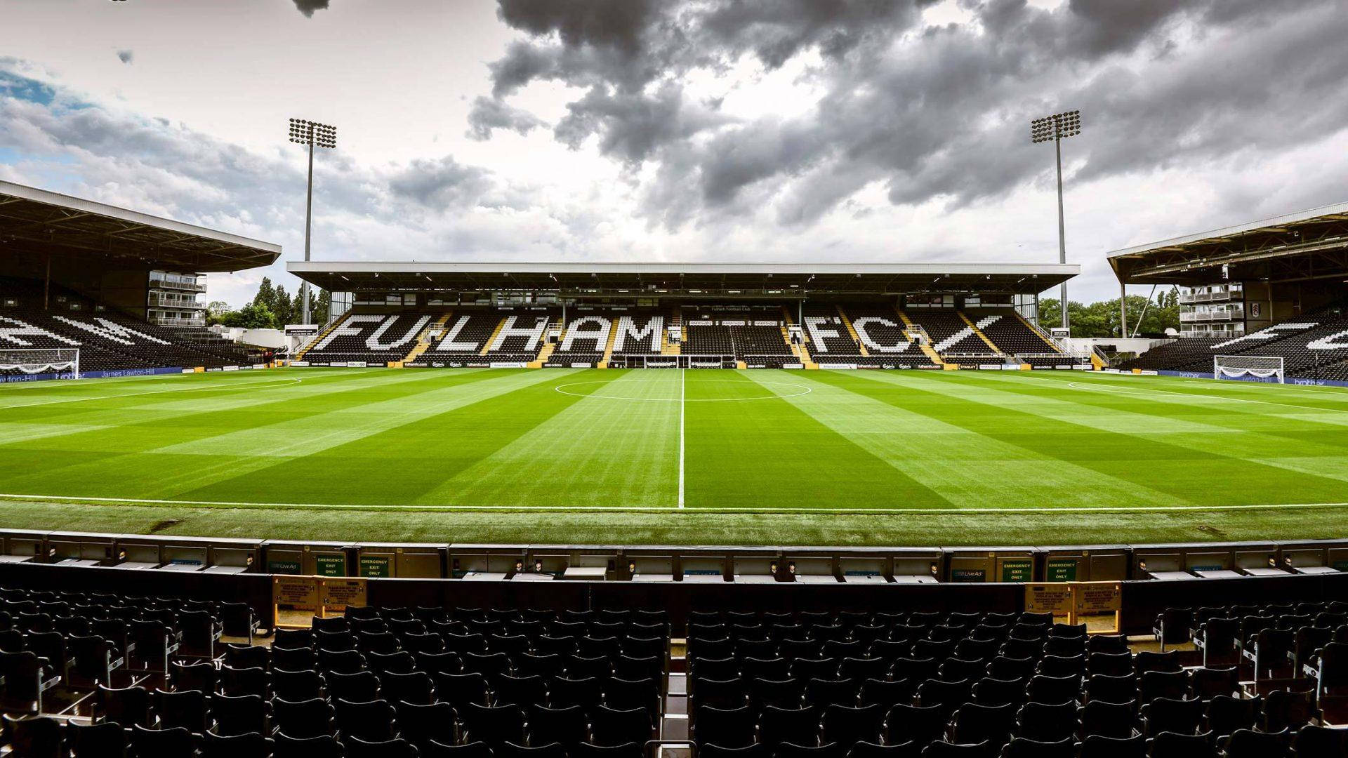 Craven Cottage 足球場，在陰天天空下，綠色草坪和空蕩蕩的看台。