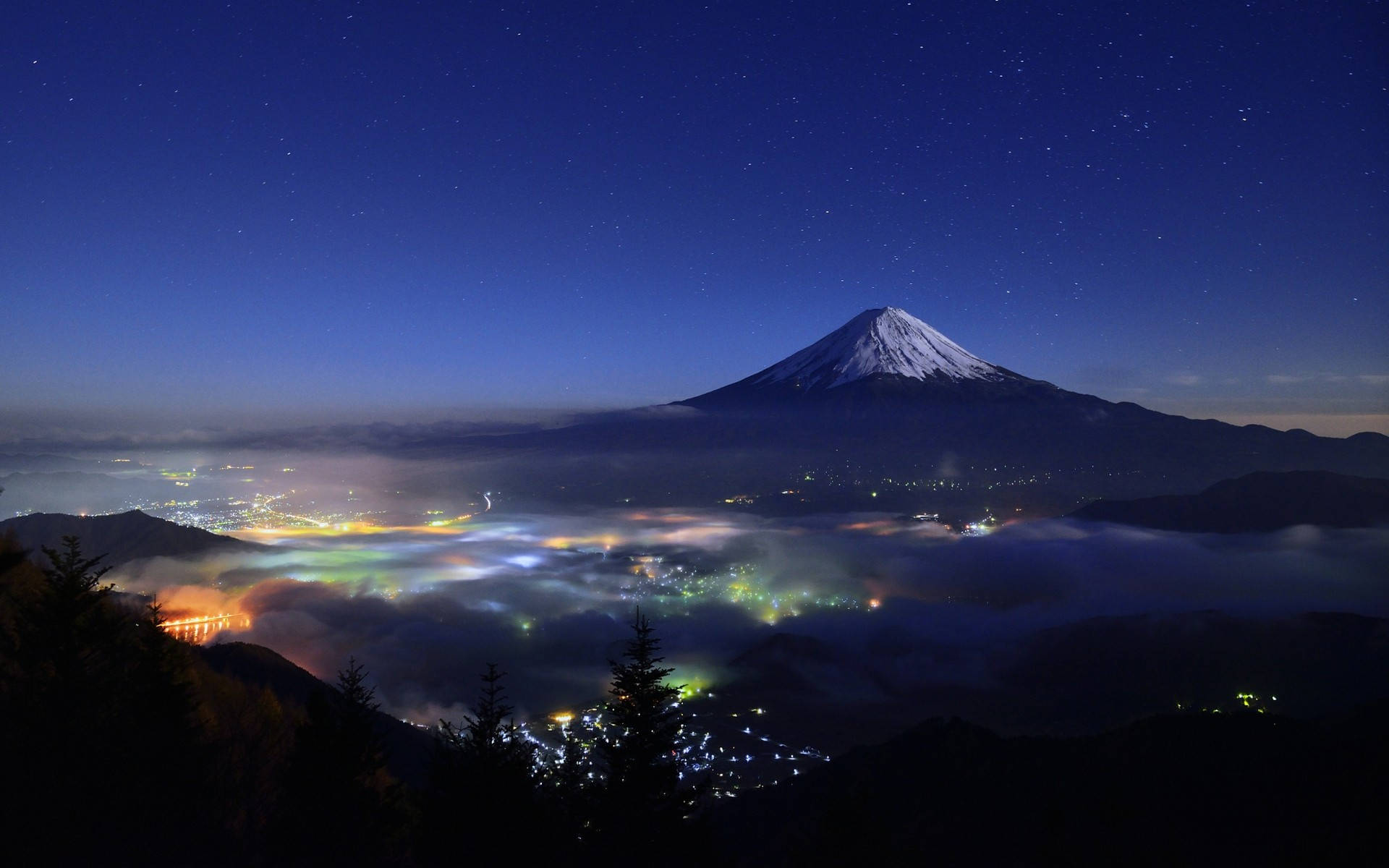 夜晚的富士山，下方是城市燈光，上方是星星