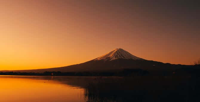 富士山在日落時分倒映在寧靜的湖面上