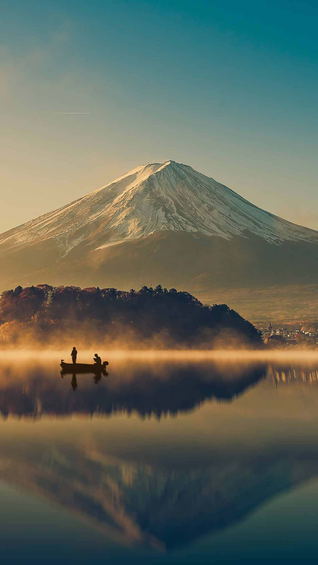 富士山與湖景 壁紙 — 寧靜的日出映照著積雪的富士山，兩人在霧氣瀰漫的湖上划船，湖面倒映著雄偉的山峰。