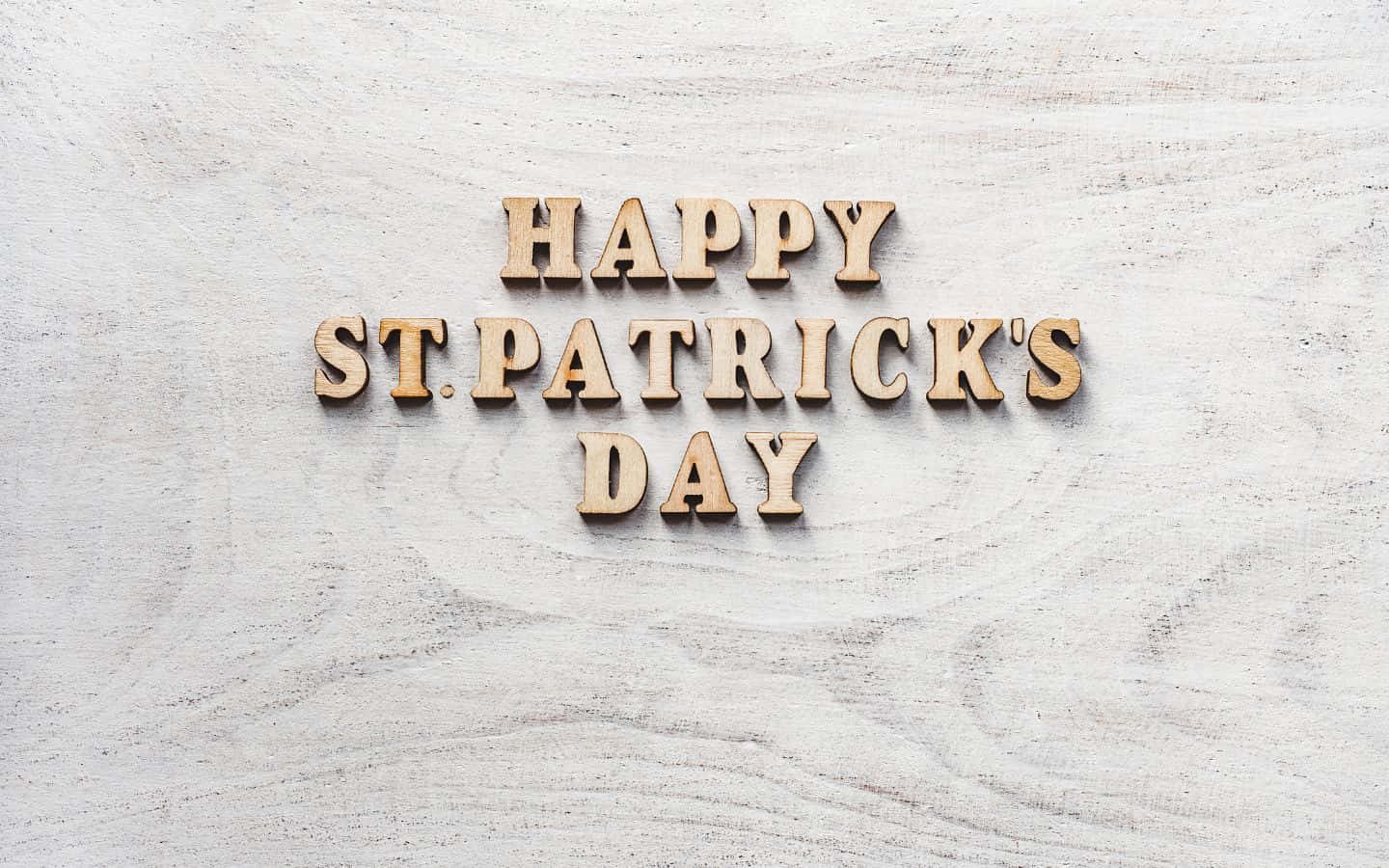 富士山靜謐湖畔的絕美風景 壁紙 — 拼出 happy st patrick's day 的木製字母放置在經風化的白色木質表面上。