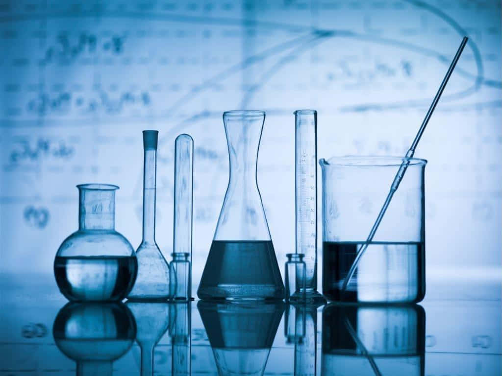裝滿液體的科學玻璃器皿放置在反光表面上，背景有公式。
