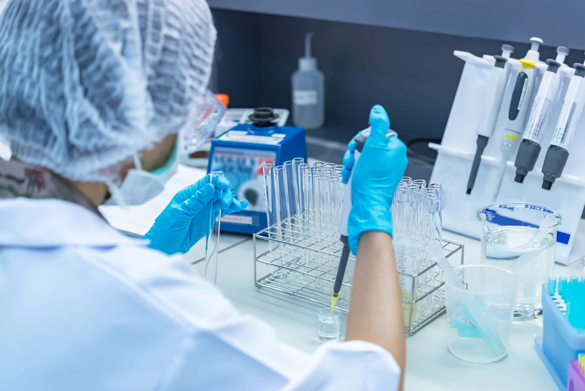 科學家在實驗室用移液器將液體注入試管