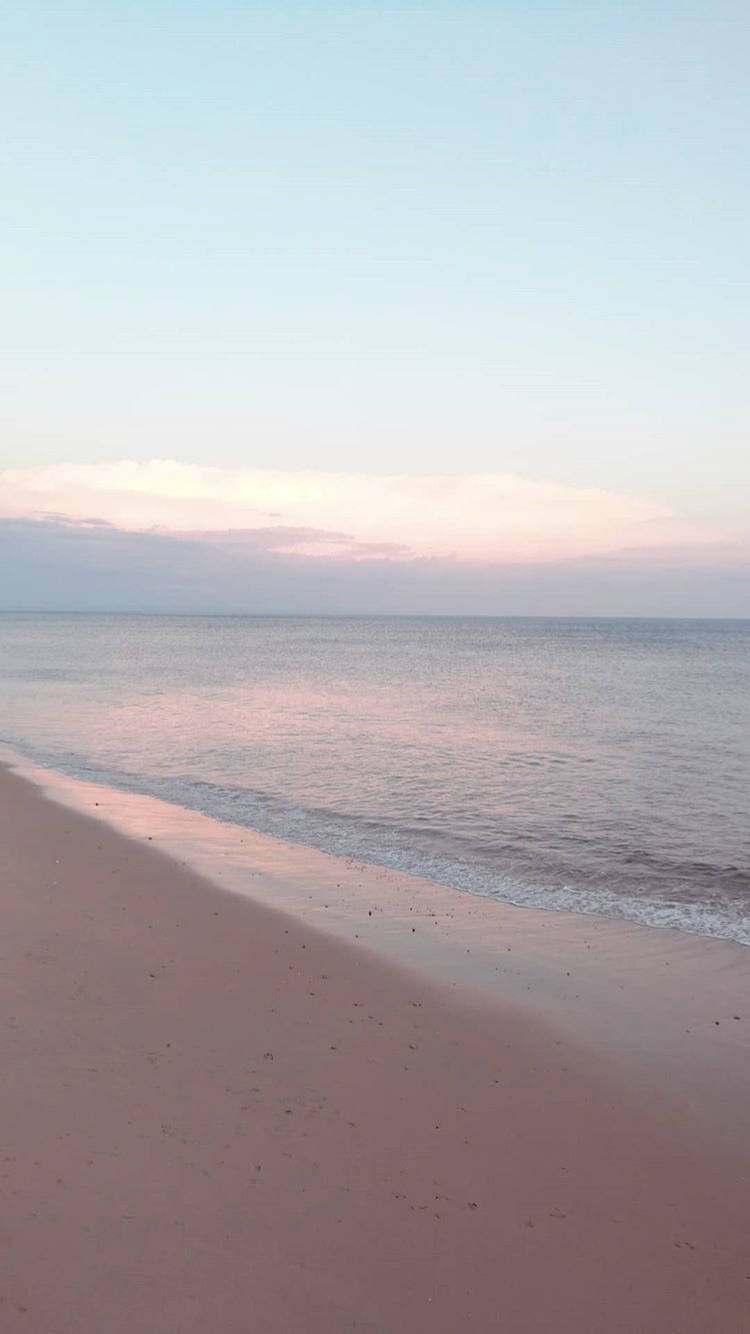 暮色中的粉紅沙灘，溫柔海浪與粉彩天空