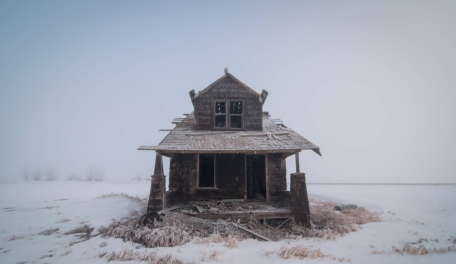 雪地上被遺棄的木屋，蒼白的冬日天空下