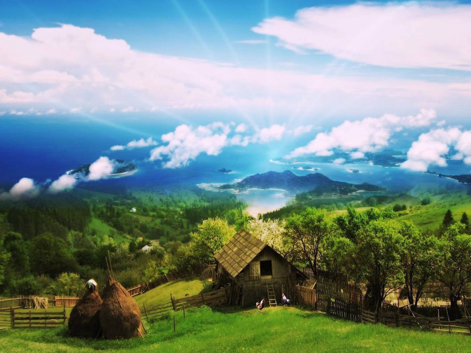 綠色山丘上的質樸小屋，俯瞰霧濛濛的海岸和藍天。