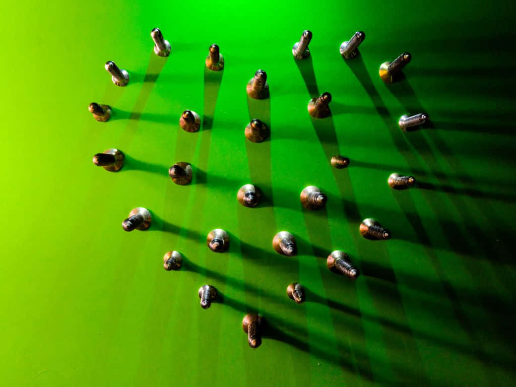 金屬螺栓排列在綠色表面上，投下清晰的陰影。