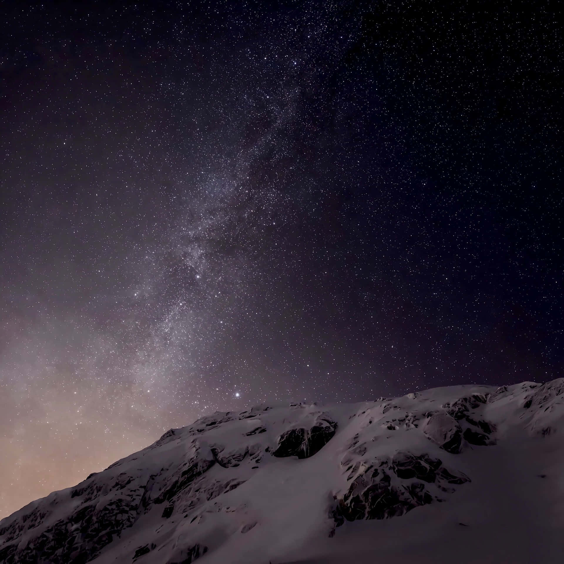 白雪覆蓋的山峰，在繁星點點的夜空下，銀河清晰可見。