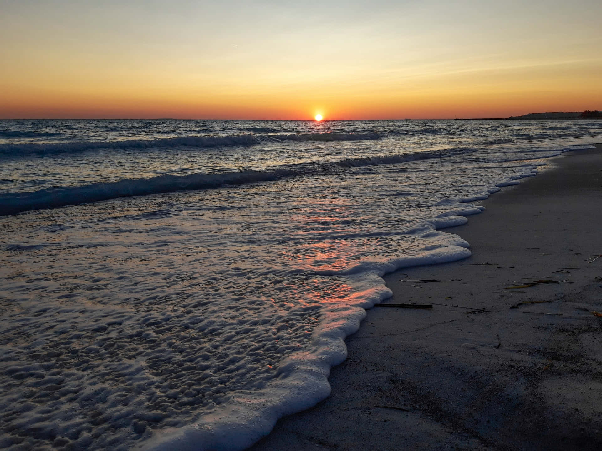 海洋上的夕陽，海浪沖刷沙灘